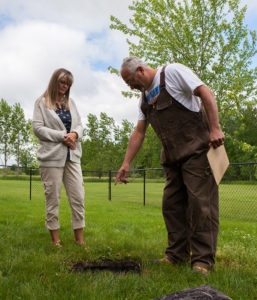 Man pointing out septic tank to woman